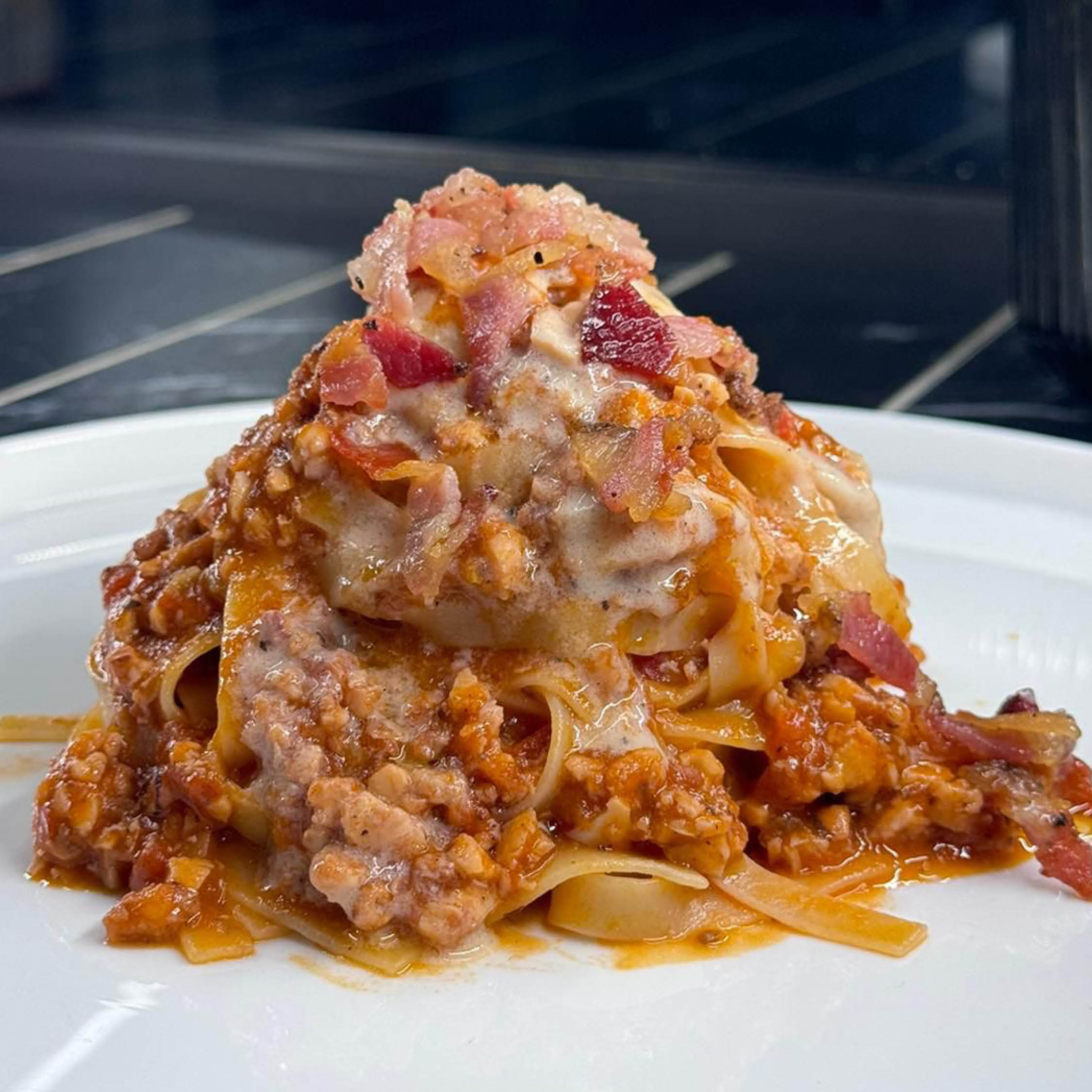 Fettuccine all'amatriciana di polpo con fonduta di pecorino e guanciale croccante 